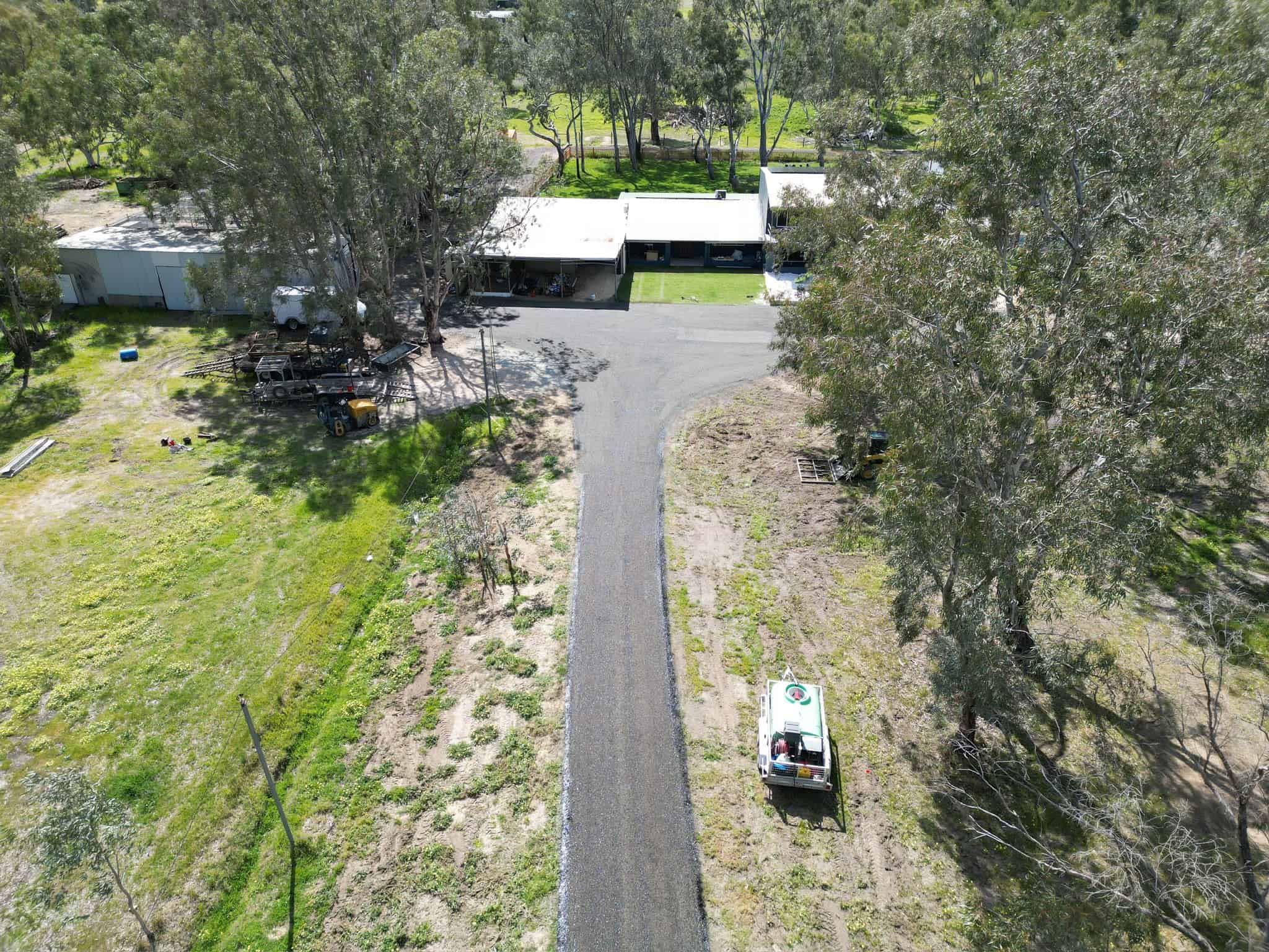 Aerial view of a rural property with a paved driveway